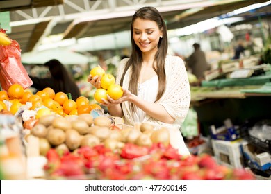 Young Woman Looking And Buying Fresh Fruit At The Market