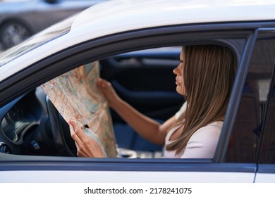 Young Woman Looking City Map Sitting On Car At Street