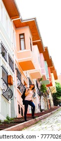 Young Woman Looking Colorful Houses On Sloppy Road