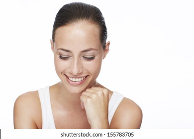 Young woman looking down and smiling in studio