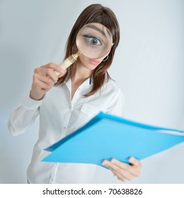  Young woman looking to a file through a magnifying glass with a shocked expression
