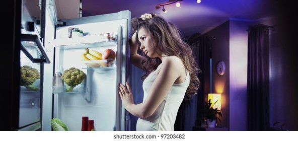 Young Woman Looking At Fridge