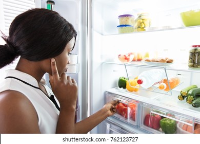 Young Woman Looking In Fridge At Kitchen - Powered by Shutterstock