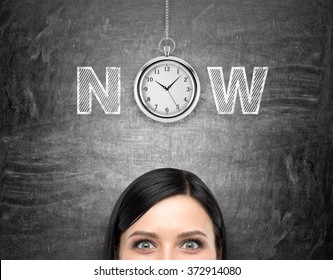 young woman looking in front of her and tthinking about present opportunities and time. A pocket watch and the word 'now' over her head. Black background. Front view. Concept of present moment.