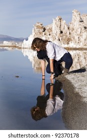 Young woman looking at her reflection at Mono Lake, California!