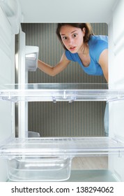 Young Woman Looking In His Empty Fridge