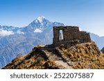 young woman looking at the imposing intipunku "gate of the sun" with the background of Nevado Veronica in Cusco Peru