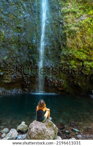 A young woman looking at the impressive waterfall at the Levada do Caldeirao Verde, Queimadas, Madeira
