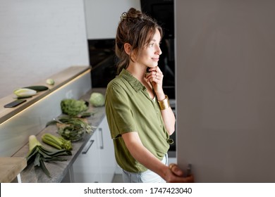 Young Woman Looking Into The Fridge, Feeling Hungry At Night