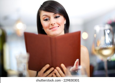 Young Woman Looking At A Menu In The Restaurant