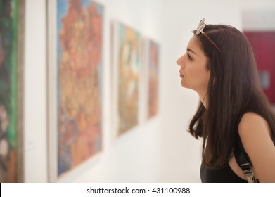 Young woman looking at modern painting in art gallery - Shutterstock ID 431100988