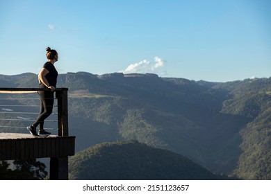 Young woman looking at mountains in a lookout viewpoint, at Cai River Valley, in Nova Petropolis, Rio Grande do Sul sierra, Brazil