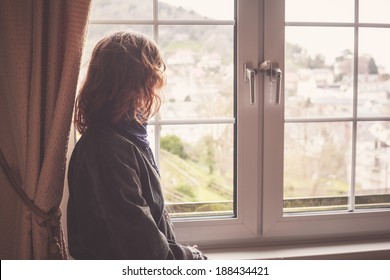 Young woman is looking out the window