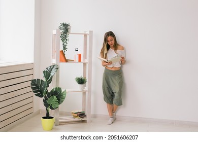 Young Woman Looking Photo Album At Home. Memories And Leisure Concept.