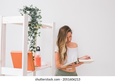 Young Woman Looking Photo Album At Home. Memories And Leisure Concept.