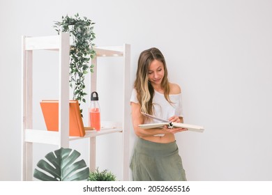 Young Woman Looking Photo Album At Home. Memories And Leisure Concept.