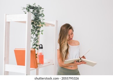 Young Woman Looking Photo Album At Home. Memories And Leisure Concept.