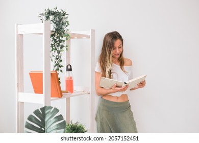 Young Woman Looking Photo Album At Home. Memories And Leisure Concept.