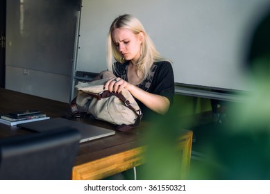 young woman looking for something in her  bag