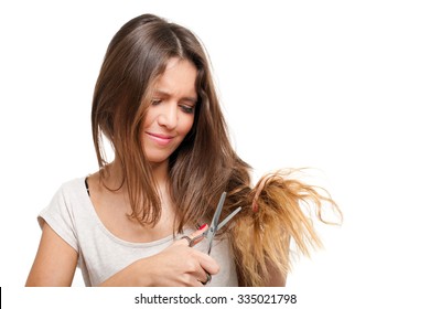 Young Woman Looking At Split Ends. Damaged Long Hair