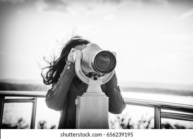 Young woman looking in spyglass