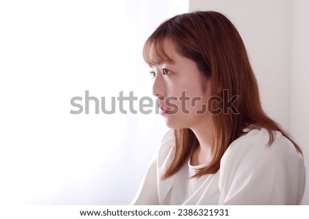 A young woman looking straight ahead with tearful eyes