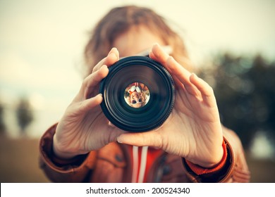 Young Woman Looking Through Camera Lens