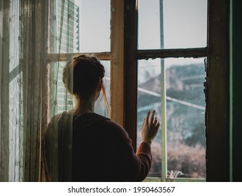 young woman looking through a window - Powered by Shutterstock