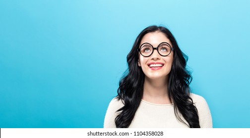 Young Woman Looking Upward On A Solid Background