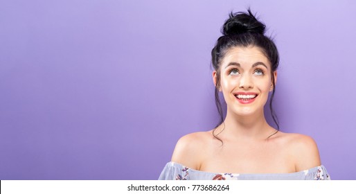 Young Woman Looking Upward On A Solid Background