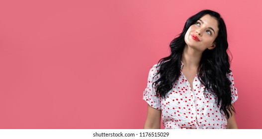 Young Woman Looking Upwards On A Solid Background