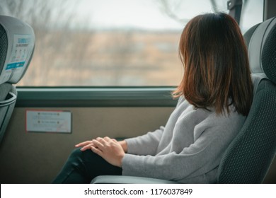 Young Woman Looking View At Window On A Bus From Airport To The City At Seoul City South Korea