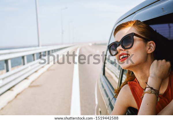 young\
woman looks into the distance sitting in a\
car
