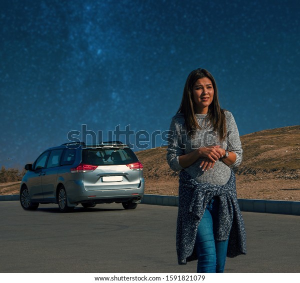 young woman\
lost in a desert. Technical problems with a broken car at night in\
the Karakum desert in\
Turkmenistan.
