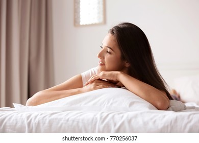 Young woman lying in bed at home