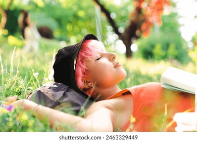 Young woman lying down on grass.She enjoys in the moment of peace. - Powered by Shutterstock