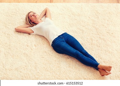 Young woman lying down on a carpet