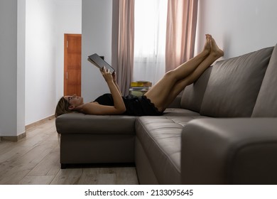 Young Woman Lying Down Reading A Book Relaxed