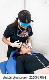 Young Woman Lying Down In Stretcher While Receiving Botulinum Toxin Injection In Beauty Clinic.