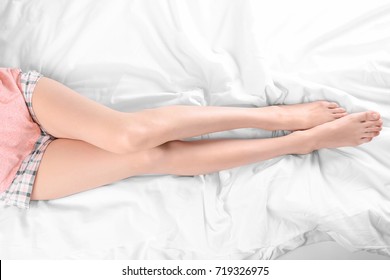 Mujer joven acostada en la cama, vista superior