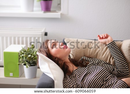Young woman lying on a couch at home