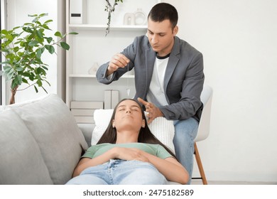 Young woman lying on sofa during hypnosis session at psychologist office - Powered by Shutterstock