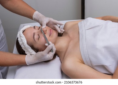 young woman lying on a stretcher in an aesthetic center performing beauty treatment and facial aesthetics with dermapen and dermaplaning techniques - Shutterstock ID 2106373676
