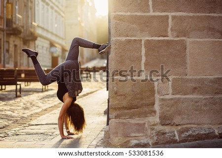 Young woman make handstand  in the summer sunny morning. Handstand exercise. Conception of youth and energy. Horizontal