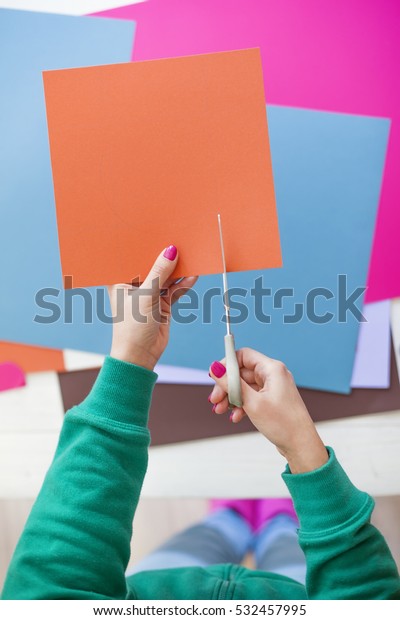 Young woman make scrapbook of the papers on the
table using antique tools for cutting paper. Hand made photo
album.Shallow depth of
field