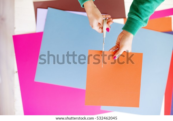 Young woman make scrapbook of the papers on the
table using antique tools for cutting paper. Hand made photo
album.Shallow depth of
field