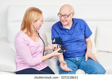 Young woman makes blood pressure measurement at a senior in home nursing