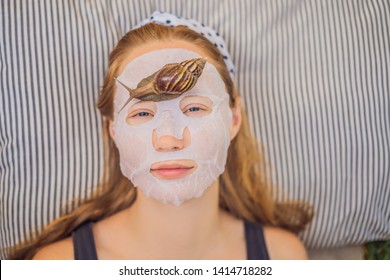 Young Woman Makes A Face Mask With Snail Mucus. Snail Crawling On A Face Mask