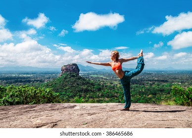 Young Woman Makes Yoga Pose On The Mountain Pidurangala Rock, Sri Lanka. Sigiriya