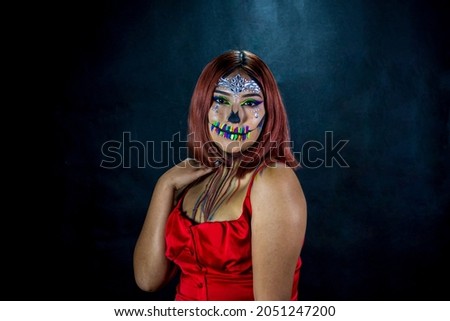 Young woman with makeup for halloween party, costume party, black gradient background and red blouse.